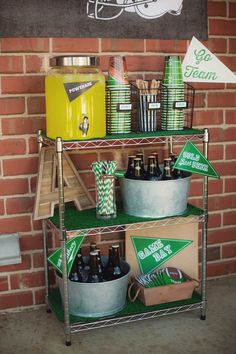 a metal shelf filled with lots of bottles and cans next to a brick wall in front of a sign that says go green