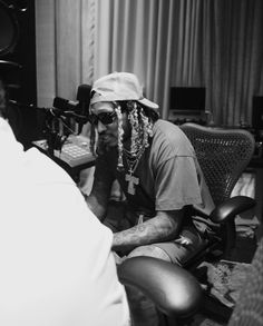 a man with dreadlocks sitting in front of a recording equipment and mixing equipment