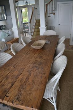 a large wooden table with white chairs around it