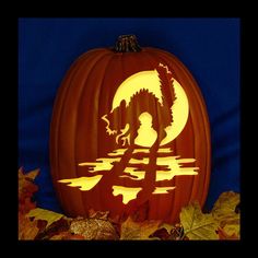 a carved pumpkin sitting on top of leaves with the moon in the sky behind it