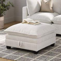 a chair and ottoman in a living room with a book on the footstool