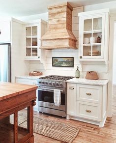 a stove top oven sitting inside of a kitchen next to a wooden dining room table