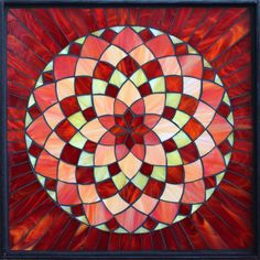 a red and yellow stained glass window with an abstract flower design on the bottom half