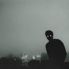 a man standing on top of a hill covered in fog