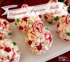 white chocolate popcorn balls decorated with candy canes and sprinkles on a plate