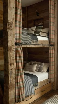 the bunk beds are made from wood and have plaid blankets on them, along with matching throw pillows