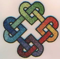 an image of a cross made out of colored thread on a white sheet with the word love written in it