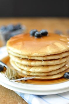 a stack of pancakes with blueberries and syrup