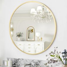 a bathroom sink with a mirror above it and a vase filled with flowers on the counter