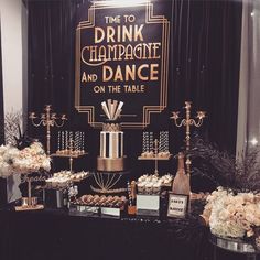 a table topped with lots of desserts and flowers next to a sign that says time to drink champagne and dance on the table