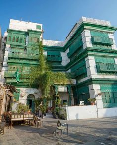 an old building with many windows and balconies on the top floor is painted green