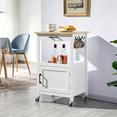 a small white bar cart with drinks on it