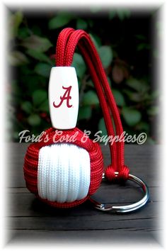 a red and white roped ball keychain with the letter a on it