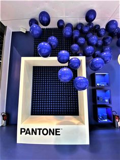 blue balloons are floating in the air above a pantone sign