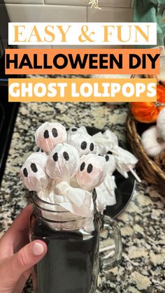 a hand holding a mason jar filled with halloween diy ghost lollipops