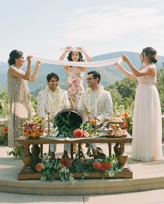 a group of people that are standing around a table