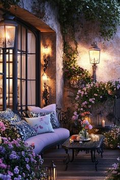 an outdoor living room with flowers and candles on the table in front of the window