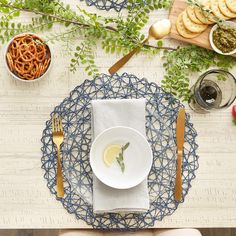 a place setting with plates, silverware and other food on a wooden table top