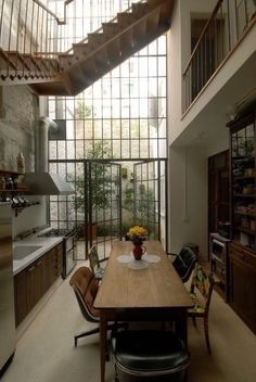 a dining room table with chairs under a stair case