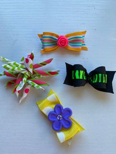 three hair bows are sitting on a table next to each other and one has a flower in the middle