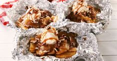 four desserts are wrapped in tin foil on a table