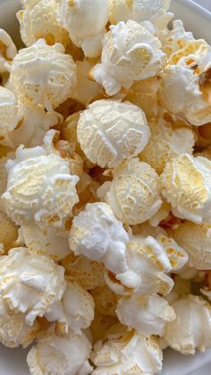 a white bowl filled with popcorn sitting on top of a table