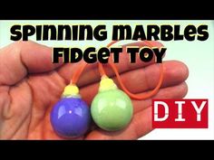 someone is holding two small toys in their hand with the words spinning marbles fidget toy diy