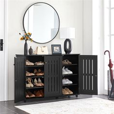 a room with a mirror, black cabinet and white rug on the floor in front of it