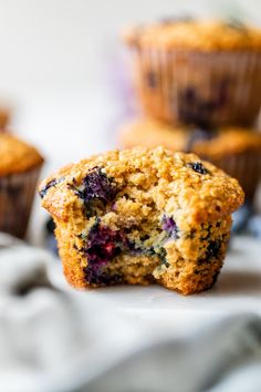 blueberry muffins sitting on top of a white cloth