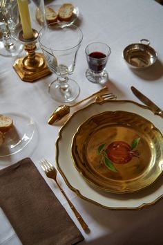 a white table topped with gold plates and silverware