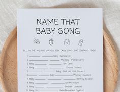 a baby song on a wooden plate next to a white sheet that says name that baby song