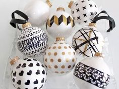 a bunch of ornaments that are sitting in a glass container on a table with black and white designs