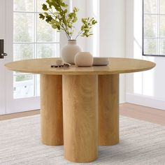 a wooden table with two vases on it and some plants in front of the table