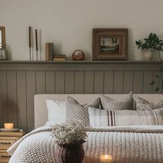 a bed with pillows, blankets and candles on it