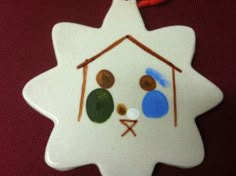 a ceramic ornament shaped like a house with eyes and nose painted on it