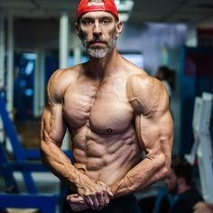 a man wearing a red hat and posing for the camera with his hands on his hips