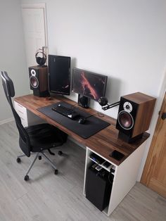 a computer desk with speakers and a keyboard