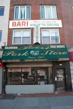 a brick building with a green awning and white lettering on the front door that says bar kiln at the sausage