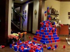 a room filled with red, white and blue cups on the floor next to a table