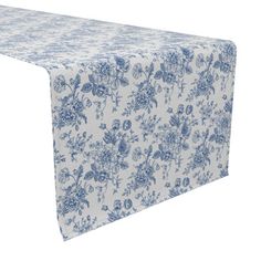 a blue and white table cloth with flowers on it, set against a white background