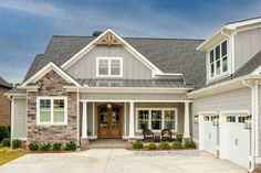 a gray house with white trim and two car garages on the front door is shown