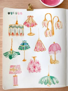 an open notebook with watercolor drawings of umbrellas, lamps and other items on it