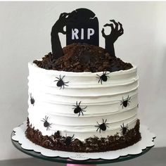 a halloween cake with white frosting and black decorations