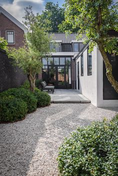 a modern house with an outdoor patio and gravel path leading up to the front door