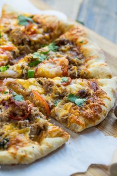 a pizza sitting on top of a wooden cutting board