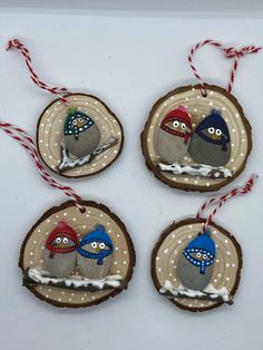 three ornaments are hanging on wood slices