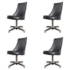 four black leather office chairs with wheels on each side and one chair up against the back