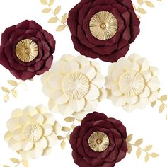 four paper flowers with gold accents on them