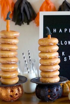 two donuts stacked on top of each other in front of a happy halloween sign