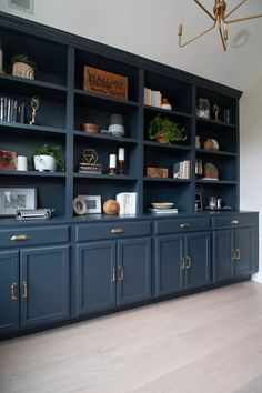 an empty room with blue bookcases and gold handles on the doors is shown